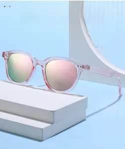 Pink transparent round frame sunglasses with gradient reflective lenses on a display stand