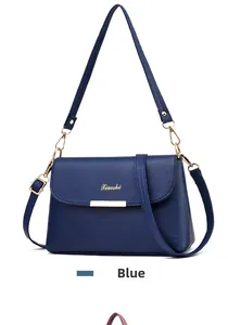 Detail der blauen Handtasche mit Litschi-Lederstruktur und goldenen Metallakzenten