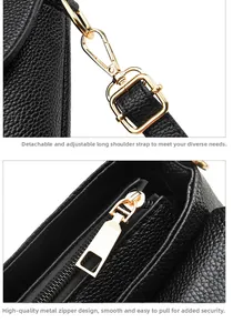 Detail einer schwarzen Tasche mit Litschi-Textur, verstellbarem Riemen und Gold-Reißverschluss