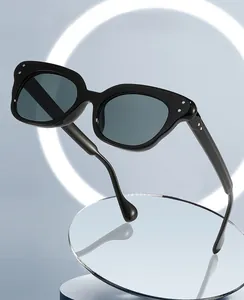 Detailed view of cat-eye sunglasses featuring black thick frames and silver metal rivets