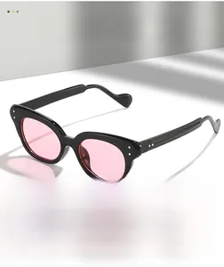 Detailed macro view of black glossy cat-eye frames with pink lenses and silver studs