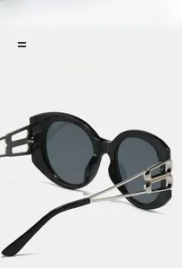 Detail of black oval sunglasses featuring silver double B hollow metal temple design