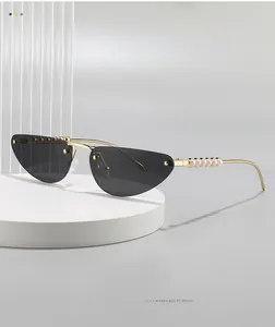 Close-up of cat-eye sunglasses with gold metal frame and white pearl details on temples