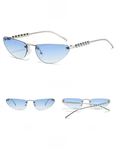 Detail of rimless cat-eye sunglasses with blue gradient lenses and pearl-accented temples