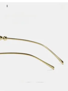 Macro detail of golden curved metal temple with decorative beads for cat eye sunglasses