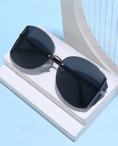 Detail of retro small round frame sunglasses with slim black metal temples and dark lenses