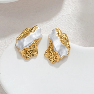 Irregular 18k gold geometric earrings with lava texture on white ceramic tray