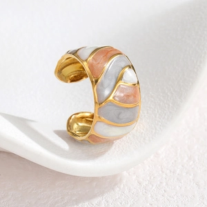 Macro detail of gold-plated open ring with wavy enamel drip texture in artistic style