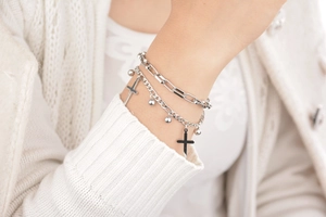 Close-up of double-layer silver cross bracelet set with paperclip chain and metal beads