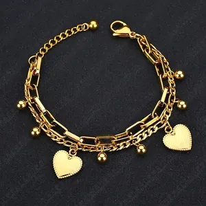 Elegant gold double-layered heart chain bracelet with round beads on black background