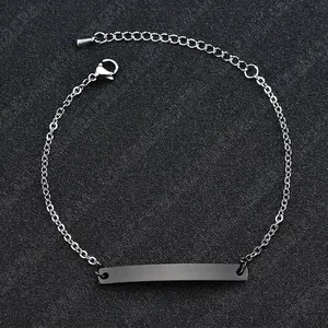 Macro detail of silver ID bracelet with polished black metal plate and lobster clasp