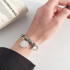 Gros plan d'un bracelet gourmette vintage en argent avec médaille et étoile