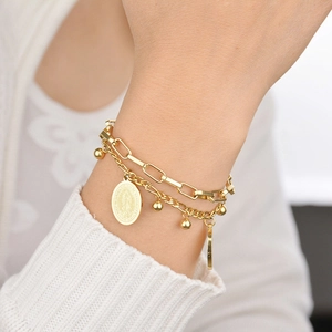 Détail d'un bracelet double couche doré avec un pendentif pièce Vierge de Guadalupe