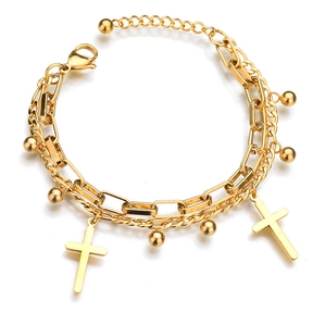Détail du bracelet double couche doré avec pendentifs en croix et perles métalliques
