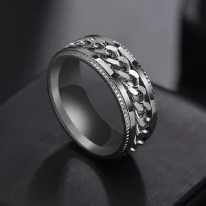Macro detail of men's stainless steel spinner ring with rotating Cuban link inlay