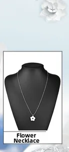 Dettaglio di una collana con ciondolo a fiore bianco a cinque petali su busto nero