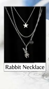 Detailed macro view of triple-layered titanium necklace with rabbit and star charms