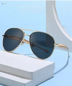 Macro view of aviator sunglasses with gold metal frame on a white geometric stand