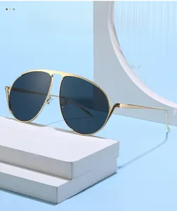 Détail de lunettes aviateur avec monture en métal doré et double pont sur socle blanc