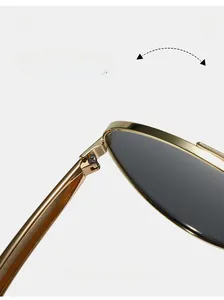Macro detail of a durable golden metal hinge on vintage aviator sunglasses with black lenses