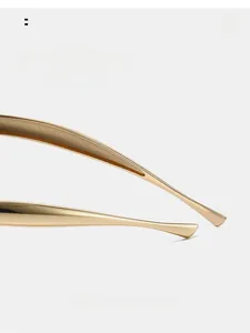 Detailed close-up of curved golden metal temples for retro aviator sunglasses