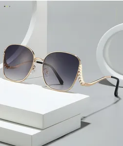 Close-up of golden metal wavy temples with sparkling rhinestone inlay on sunglasses