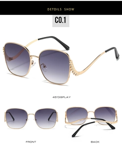 Detail view of large gold metal frame sunglasses with purple gradient lenses and rhinestones