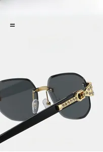 Detailed close-up of gold metal hinge with rhinestones on rimless square sunglasses