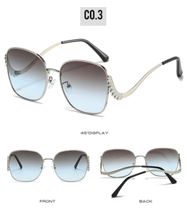 Detail view of large metal sunglasses showing wave textures and gradient lenses