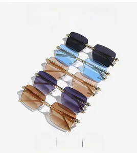 Macro view of rimless rectangle sunglasses showing gold metal temples and striped texture