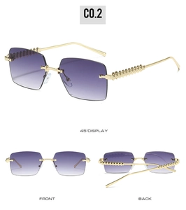 Detail view of gold rimless sunglasses with purple gradient lenses and textured metal temples