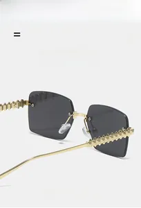 Detail of grey gradient square lens and gold metal temples with punk spike decoration