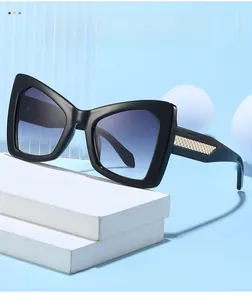 Detail of cat-eye sunglasses featuring golden metal mesh texture on black temples