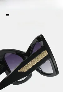 Detail view of black oversized sunglasses temples featuring golden woven metal texture inserts