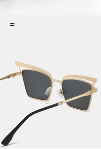 Close-up of golden cat-eye metal frame sunglasses with textured hinge detail
