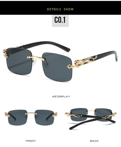 Détail de lunettes de soleil carrées sans monture avec panthère dorée sur la branche