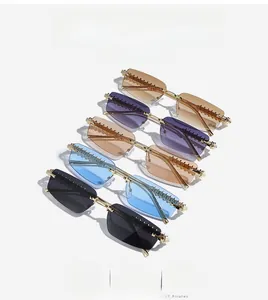 Five assorted rimless sunglasses with gold-colored metal temples on white background