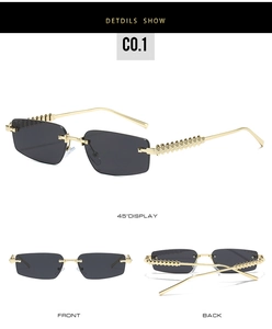 Detail view of narrow rimless sunglasses with spiked gold metal temples and grey lenses