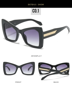 Detail of oversized sunglasses with purple gradient lenses and gold woven temple accents