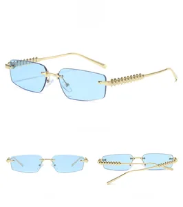Detail of rimless rectangle sunglasses with blue lenses and gold studded temples