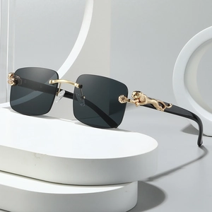 Lunettes de soleil carrées sans monture avec branches léopard dorées sur fond blanc