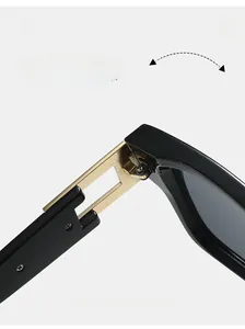 Détail de la charnière en métal doré sur des lunettes de soleil rétro noires au design