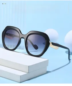 Gros plan de lunettes de soleil carrées avec verres dégradés bleus et détails dorés
