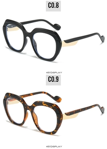 Détail de lunettes carrées à monture épaisse en noir et écaille avec charnières dorées