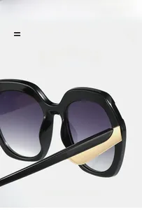 Détail de lunettes de soleil carrées avec monture noire, branches dorées et verres dégradés violets