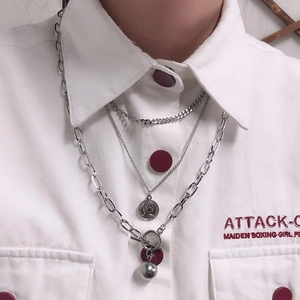 Detail of silver layered hip-hop necklaces with coin pendant and thick chain links