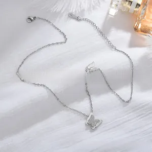 Close-up of a silver butterfly pendant necklace with glittery texture on white linen
