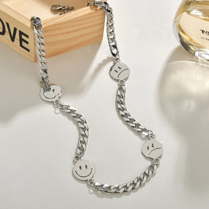 Détail macro du collier chaîne cubaine en acier inoxydable avec pendentifs emoji