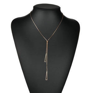 Elegant rose gold titanium Y-necklace with geometric triangle pendants on black mannequin