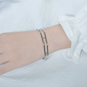 Detail view of a minimalist multilayer silver geometric open cuff bracelet on a female wrist